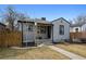 Inviting home exterior with gray siding, black trim, and a well-manicured lawn at 1705 S Downing St, Denver, CO 80210