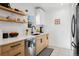 Modern kitchen with stainless steel appliances, light wood cabinets, and floating shelves at 1705 S Downing St, Denver, CO 80210