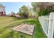 Large backyard with a horseshoe game pit, white picket fence, and plenty of room for outdoor activities at 5332 W Roxbury Pl, Littleton, CO 80128