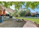Landscaped backyard with white picket fence, covered patio, grill, and a fire pit at 5332 W Roxbury Pl, Littleton, CO 80128
