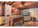 Finished basement with game area, exposed brick pillar, and low ceilings at 5332 W Roxbury Pl, Littleton, CO 80128