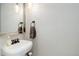 Powder room with pedestal sink, decorative mirror, and modern lighting at 5332 W Roxbury Pl, Littleton, CO 80128