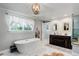 Bathroom with soaking tub, dual vanity, and stylish light fixture at 5332 W Roxbury Pl, Littleton, CO 80128