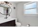 Modern bathroom with a round mirror, dark vanity, and a walk-in shower with white subway tile at 5332 W Roxbury Pl, Littleton, CO 80128