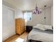 Cozy bedroom featuring a plush bed, closet and dresser with a charming purple chandelier at 5332 W Roxbury Pl, Littleton, CO 80128