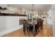 Open-concept dining area with a fireplace, chandelier, and view into kitchen at 5332 W Roxbury Pl, Littleton, CO 80128