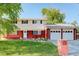 Charming two-story home with a brick facade, manicured lawn, and a two-car garage at 5332 W Roxbury Pl, Littleton, CO 80128