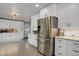 Bright kitchen features white cabinetry, stainless steel refrigerator, and tiled backsplash at 5332 W Roxbury Pl, Littleton, CO 80128