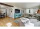 Inviting living area featuring hardwood floors, neutral furniture, and a modern entertainment center at 5332 W Roxbury Pl, Littleton, CO 80128