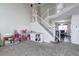 Two-story living room with carpeted floors and staircase at 11673 Josephine St, Thornton, CO 80233