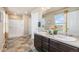 Well-lit bathroom with double sinks, a shower, and neutral-toned walls at 567 Jewel St, Brighton, CO 80603