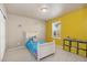 Cozy bedroom featuring carpeted floors, natural light from window, and bright yellow accent wall at 567 Jewel St, Brighton, CO 80603