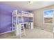 Bedroom with ladder to bunk, under-bed desk, natural light from window, and purple accent wall at 567 Jewel St, Brighton, CO 80603