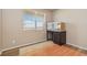 Cozy bedroom with hardwood floors, a large window, and a built in desk with drawers at 567 Jewel St, Brighton, CO 80603