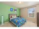 Bedroom with bright green accent wall, carpeted floors, and natural light from window at 567 Jewel St, Brighton, CO 80603