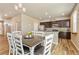 Bright dining area featuring wood floors, a dining table with seating, and an open layout to the kitchen at 567 Jewel St, Brighton, CO 80603