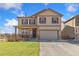 Charming two-story home featuring a two-car garage, front porch, and neutral exterior paint at 567 Jewel St, Brighton, CO 80603