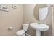 Stylish half bathroom with a pedestal sink, modern fixtures, and a decorative mirror at 567 Jewel St, Brighton, CO 80603