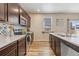 Well-equipped kitchen with stainless steel appliances, tile backsplash, and dark wood cabinets at 567 Jewel St, Brighton, CO 80603