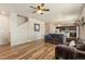 Spacious living room featuring wood floors, a fireplace, a ceiling fan, and an open layout at 567 Jewel St, Brighton, CO 80603