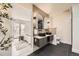 Bathroom features dual sinks, sleek black tile floors, and doorway to the bedroom at 51 S Eaton St, Lakewood, CO 80226