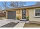 Close-up of the home's entrance featuring a modern front door, wood accents, and landscaping at 51 S Eaton St, Lakewood, CO 80226