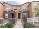 Inviting townhome exterior with brick accents and lovely landscaping around a sidewalk entrance at 15443 W 65Th Ave # B, Arvada, CO 80007