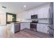 Well-lit kitchen with white cabinetry, stainless steel appliances, and an open layout at 15443 W 65Th Ave # B, Arvada, CO 80007