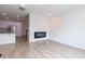 Contemporary living room with sleek electric fireplace and modern, light wood-look floors at 15443 W 65Th Ave # B, Arvada, CO 80007
