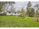 Sprawling green backyard with mature trees bordering a home with white siding at 5370 S Sherman St, Littleton, CO 80121