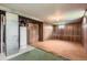 This is a mostly unfinished basement area with carpet and wood-paneled walls at 5370 S Sherman St, Littleton, CO 80121