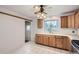 Traditional kitchen with white tile floor, light wood cabinets, and an open window view to the backyard at 5370 S Sherman St, Littleton, CO 80121