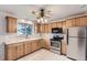 Traditional kitchen with stainless steel appliances, light wood cabinets, a ceiling fan, and bright natural light at 5370 S Sherman St, Littleton, CO 80121