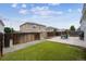 Wide view of a fenced backyard with a patio, grill, and green lawn at 20765 E 39Th Ave, Denver, CO 80249