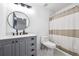 Bathroom with modern vanity, decorative mirror, patterned floors, and a shower with a striped curtain at 20765 E 39Th Ave, Denver, CO 80249