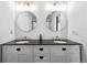 Modern bathroom featuring a double vanity with granite countertops, gold fixtures, and dual round mirrors at 20765 E 39Th Ave, Denver, CO 80249