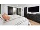 Stylish bedroom featuring a comfortable bed, modern dresser, and a barn door leading to the bathroom at 20765 E 39Th Ave, Denver, CO 80249
