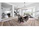 Open concept dining area with stylish chandelier, wood floors, modern furniture, and view of the updated kitchen at 20765 E 39Th Ave, Denver, CO 80249