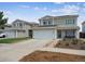 Two-story home featuring solar panels, an attached garage, landscaping, and a welcoming blue front door at 20765 E 39Th Ave, Denver, CO 80249