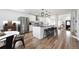 Modern kitchen with white cabinets, stainless steel appliances, a large island and view into the dining room at 20765 E 39Th Ave, Denver, CO 80249