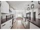 Open concept kitchen with white cabinets, stainless steel appliances, large island and view into the dining room at 20765 E 39Th Ave, Denver, CO 80249