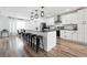 Modern kitchen with white cabinets, stainless steel appliances, and a large island with bar seating at 20765 E 39Th Ave, Denver, CO 80249