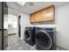 Well-equipped laundry room with modern washer and dryer, ample cabinet space, and decorative patterned flooring at 20765 E 39Th Ave, Denver, CO 80249