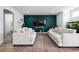 Bright living room featuring comfortable sofas, hardwood floors, a modern TV setup, and stylish decor at 20765 E 39Th Ave, Denver, CO 80249