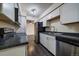 Kitchen featuring white cabinets, stainless steel appliances, and black countertops at 4569 S Lowell Blvd # B, Denver, CO 80236