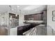 Modern kitchen featuring a large island and dark wood cabinets at 26994 E Indore Ave, Aurora, CO 80016