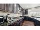 Modern kitchen with dark wood cabinets and granite countertops at 26994 E Indore Ave, Aurora, CO 80016