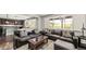 Open living room with leather sofas, a coffee table, and a view of the kitchen at 26994 E Indore Ave, Aurora, CO 80016