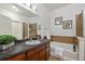 A luxurious bathroom featuring an expansive mirror, modern fixtures, and a shower-tub combo at 10184 Park Meadows Dr # 1102, Lone Tree, CO 80124