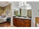 Stylish bathroom featuring a dark wood vanity, large mirror, and an open view to a bedroom at 10184 Park Meadows Dr # 1102, Lone Tree, CO 80124